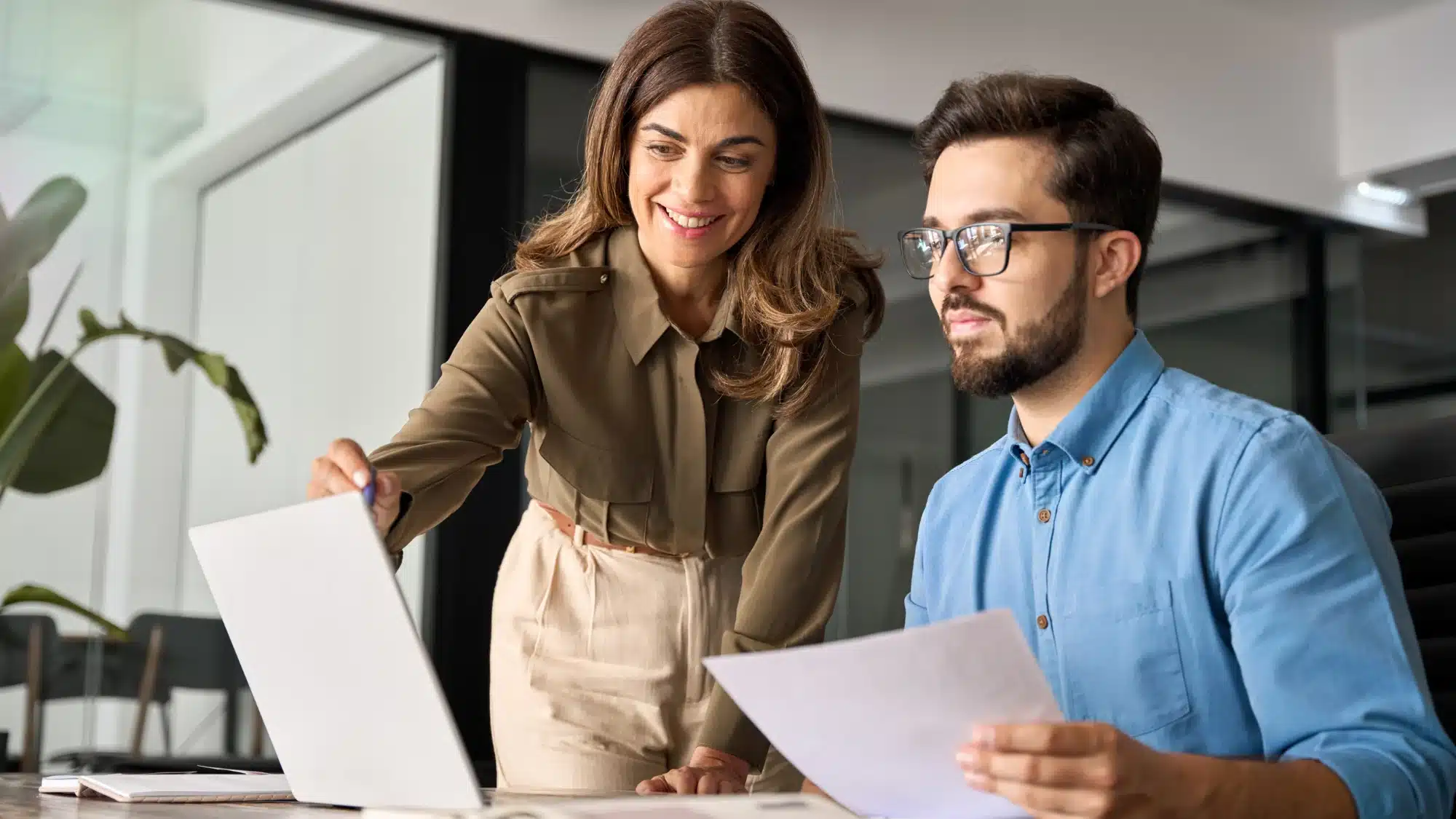 small business owner reviewing pooled employer retirement plan options with financial documents and advisor guidance in an office setting